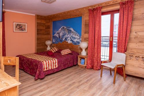 a bedroom with a bed and a mountain painting on the wall at Hotel Chaberton in Cesana Torinese
