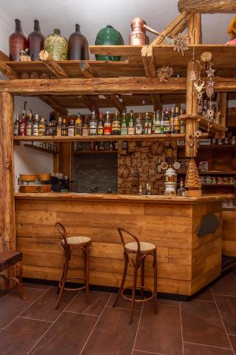 a wooden bar with two stools in a room at Hotel Chaberton in Cesana Torinese