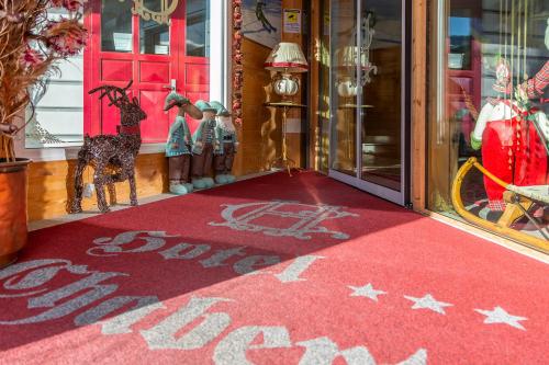 a red welcome mat in front of a red door at Hotel Chaberton in Cesana Torinese
