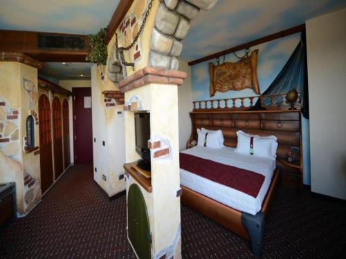 a bedroom with a bed in a room with a fireplace at Grand Hotel Mattei in Ravenna