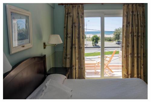 a bedroom with a bed and a window with a view at Hosteria Solar de la Costa in Puerto Madryn