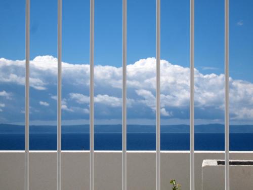 a view of the ocean from behind a building at Apartments House Filipović in Makarska