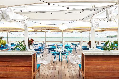 a restaurant with blue chairs and tables and umbrellas at The Standard Miami in Miami Beach