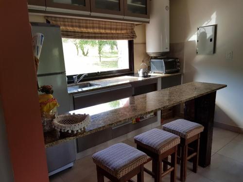 a kitchen with a counter with stools and a sink at La Morada in Purmamarca