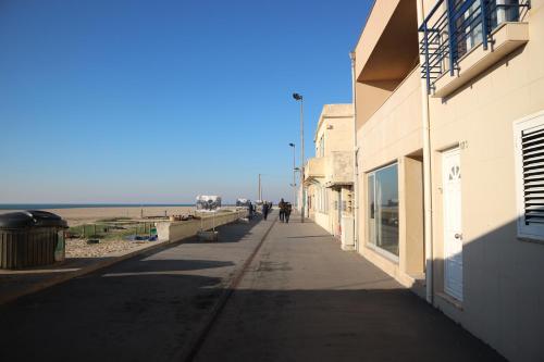 a sidewalk next to a building and the beach at House In Aguda Beach, praia da Aguda, in Aguda
