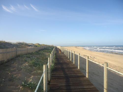 a wooden boardwalk leading to a beach with the ocean at House In Aguda Beach, praia da Aguda, in Aguda