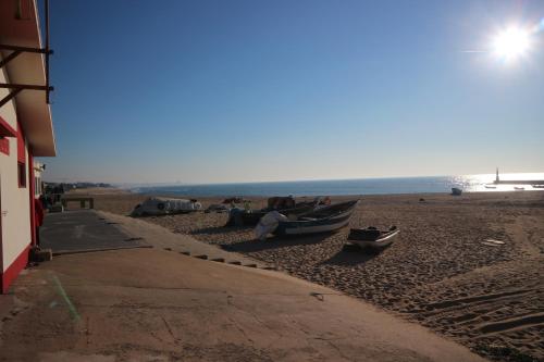 a group of people sitting in boats on the beach at House In Aguda Beach, praia da Aguda, in Aguda