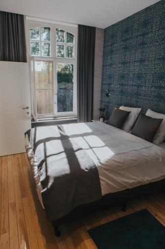 a bedroom with a large bed and a window at Découverte in Ieper