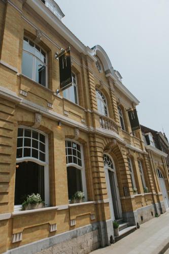 a brick building with windows and a sign on it at Découverte in Ypres