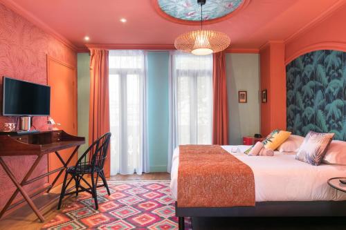a bedroom with a bed and a desk and a television at Villa Bougainville by Happyculture in Nice