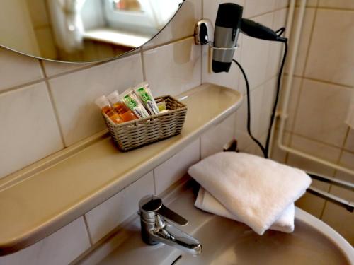 a bathroom sink with a mirror and a towel at Hotel & Gasthaus Zum Domkreuger in Walsrode