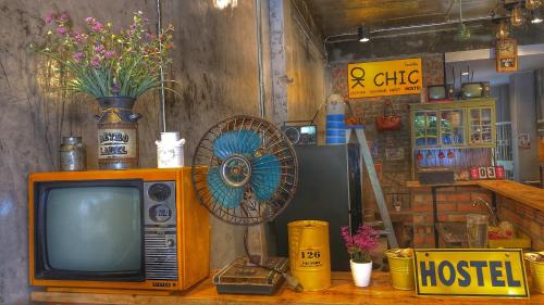 an old tv sitting on a table with a fan at OK CHIC PHUKET HOSTEL in Phuket Town