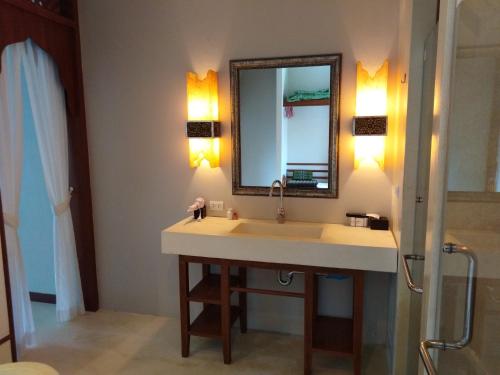 a bathroom with a sink and a mirror at C-VIEW BOUTIQUE in Rawai Beach