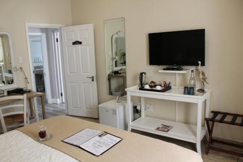 a living room with a flat screen tv on a wall at Sandals Guest House in Durban