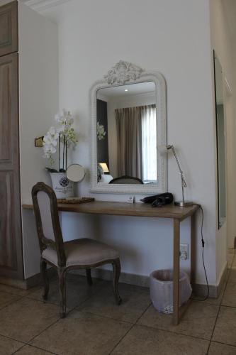 a desk with a mirror and a chair in a room at Sandals Guest House in Durban