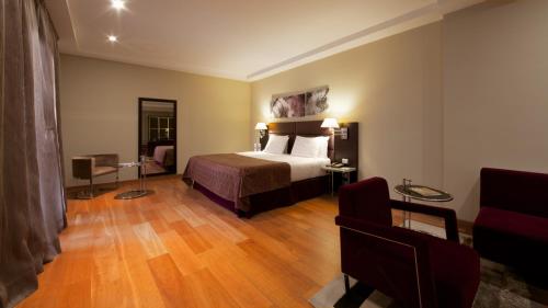 a hotel room with a bed and a chair at Eurostars Roma Aeterna in Rome