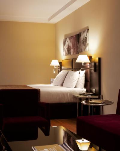 a hotel room with a bed and two tables at Eurostars Roma Aeterna in Rome