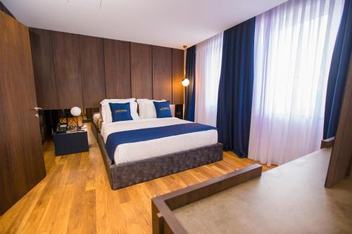a bedroom with a bed with blue and white pillows at Astoria Luxury & SPA in Gjilan