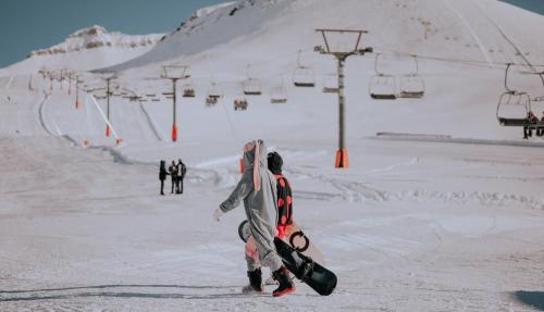 Ski Heaven في غودواري: شخص يمشي في الثلج مع لوح التزلج