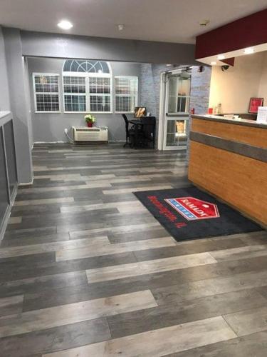 an empty room with wooden floors and a kitchen at Ramada by Wyndham Bloomington I-55 and I-74 IL in Bloomington