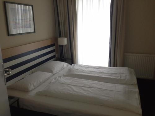 Bett in einem Hotelzimmer mit Fenster in der Unterkunft Komfortapartment Zingster-Meerblick in Zingst