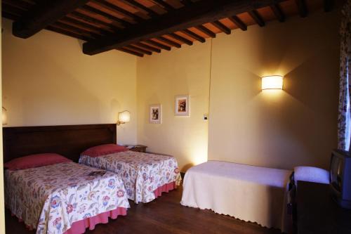 a bedroom with two beds and lights on the wall at Le Fonti A San Giorgio in Montespertoli