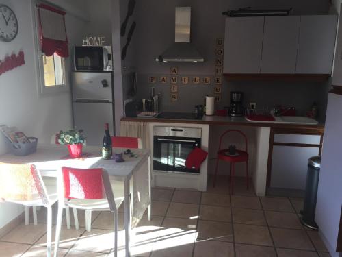 a kitchen with a table and chairs and a stove at Clos des Templiers in Saint-Rémy-de-Provence