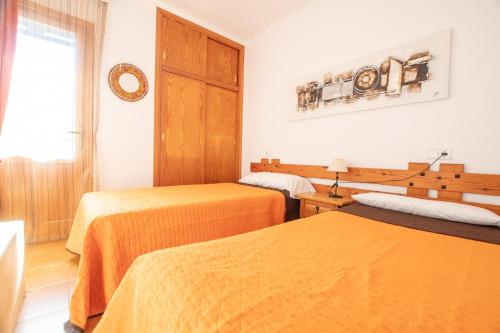 a hotel room with two beds and a window at Bosc i Sol VT in Es Calo