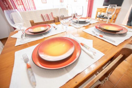 a wooden table with plates and glasses on it at Bosc i Sol VT in Es Calo