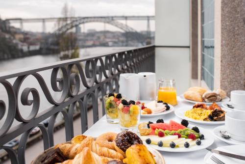 a table with plates of breakfast food on a balcony at Eurostars Porto Douro in Porto