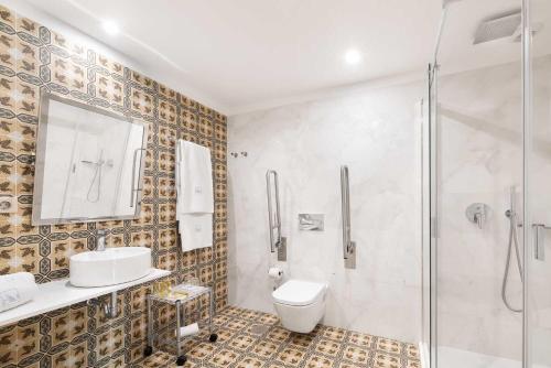 a bathroom with a shower and a toilet and a sink at Eurostars Porto Douro in Porto