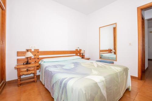 a bedroom with a bed and a table and a mirror at Bosc i Sol VT in Es Calo