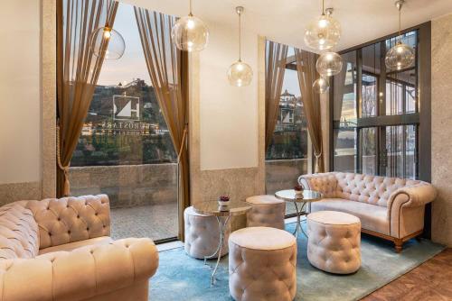a lobby with two couches and tables and a window at Eurostars Porto Douro in Porto