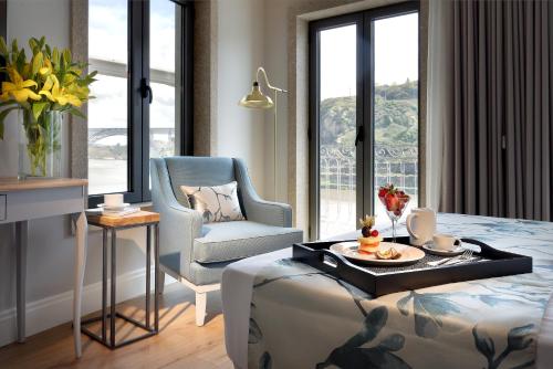 a bedroom with a bed and a chair and a table at Eurostars Porto Douro in Porto