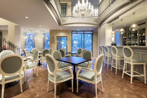 a dining room with tables and chairs and a chandelier at Eurostars Porto Douro in Porto