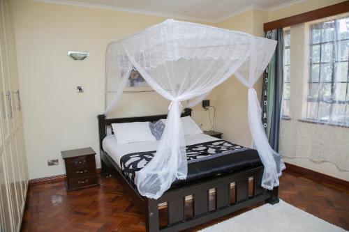 a bedroom with a bed with a canopy at Orchid Homes, Gigiri in Nairobi