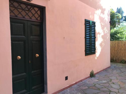 a pink house with a black door and a window at San domenico 18 in Florence