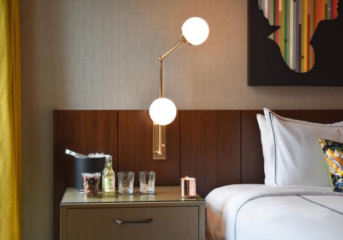 a hotel room with a bed and a table with glasses at The Darcy Hotel, Washington DC in Washington