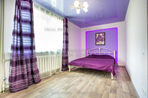 a purple bedroom with a bed and a window at Apartment Perekopska st. in Kherson