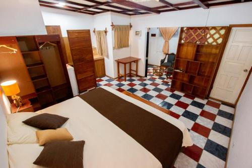 a bedroom with a large bed and a checkered floor at Maytenus Galapagos in Puerto Ayora