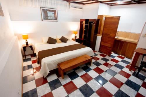 a bedroom with a bed and a checkered floor at Maytenus Galapagos in Puerto Ayora