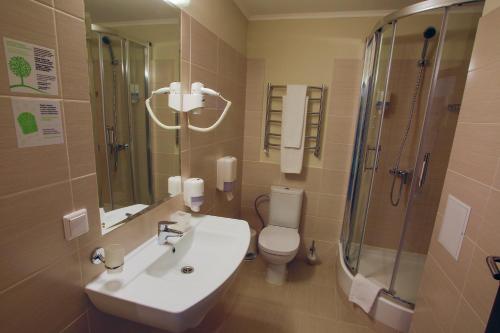 a bathroom with a sink and a toilet and a shower at Optima Cherkasy Hotel in Cherkasy