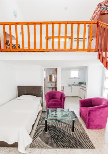 a bedroom with a bed and two purple chairs at Citrus Tree Gardens in Kyrenia