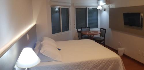 a bedroom with a bed and a table and a television at Hotel Solaris in São Miguel dʼOeste