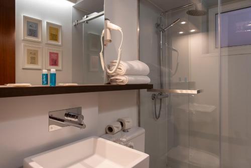 uma casa de banho com um lavatório e um chuveiro em Hotel Samasa Fundao em Fundão