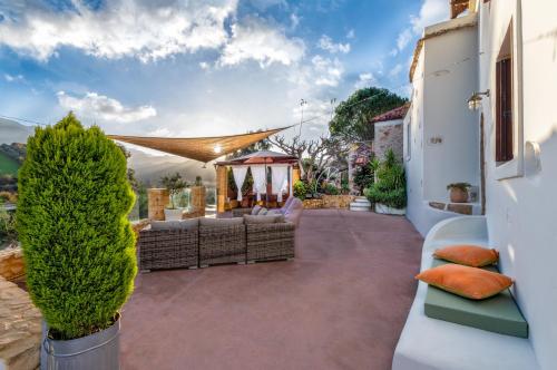 a patio with a couch and a gazebo at Verekinthos Villas - Pool, Hot Tub, BBQ, Kids Playground, Stunning Mountain Views in Gerolakkos
