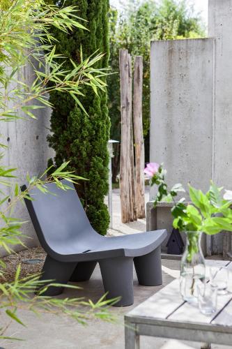 a bench in a garden with a table and plants at Le392Bis in Échiré