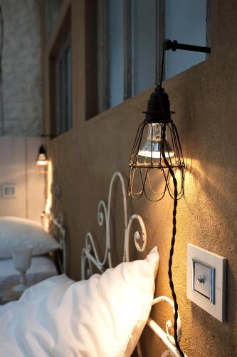 a lamp hanging from a wall next to a bed at Le392Bis in Échiré