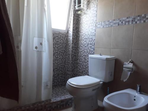 a bathroom with a toilet and a shower and a sink at Maraja1 in Mar de Ajó