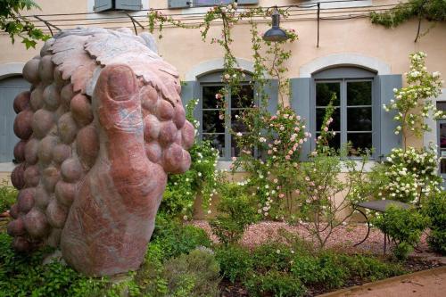 a statue of a chicken in front of a building at Logis Hotel - Restaurant La Marbrerie in Caunes-Minervois